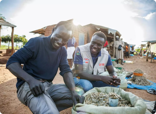Two smiling entrepreneurs inspecting produce at an open-air market